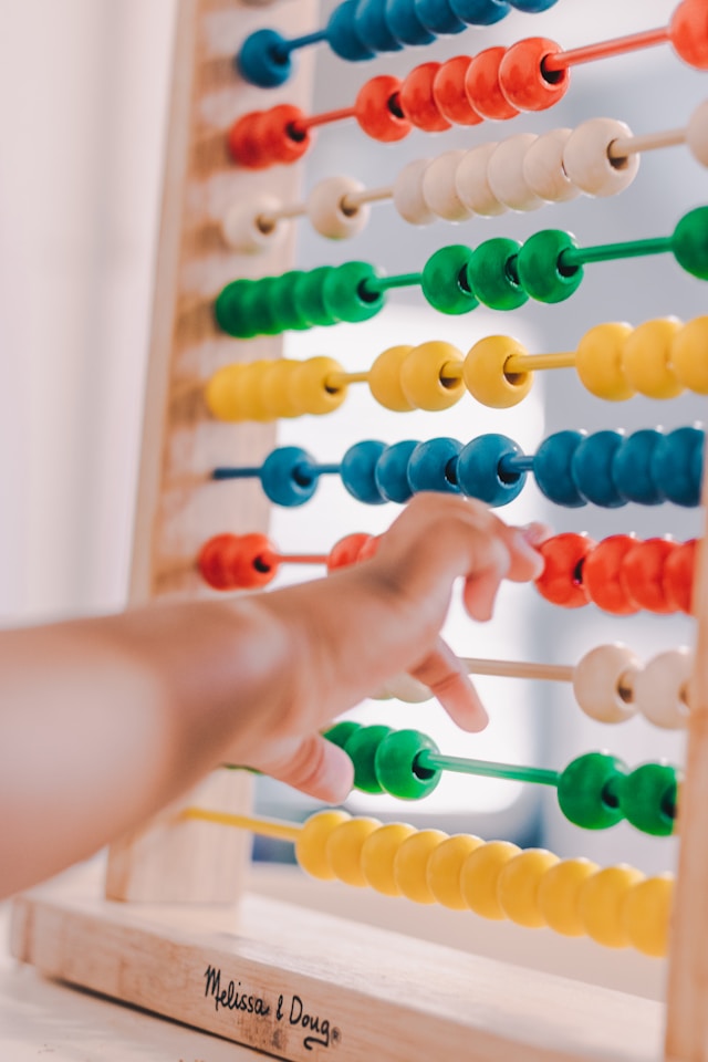 Childs arm playing with an abacus