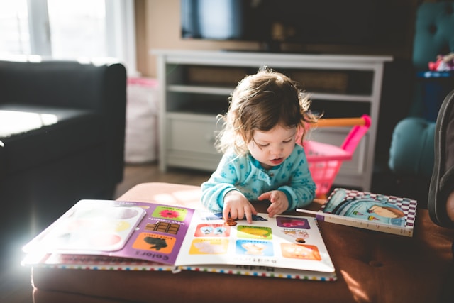 little girl looking at a picture book